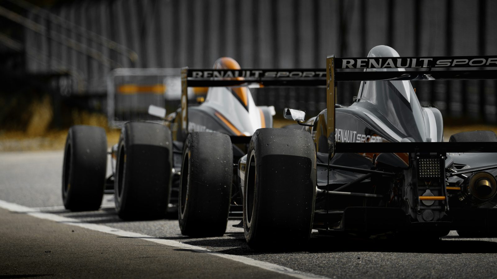 Two Renault Sport single-seaters lined up on track, seen from behind at low angle