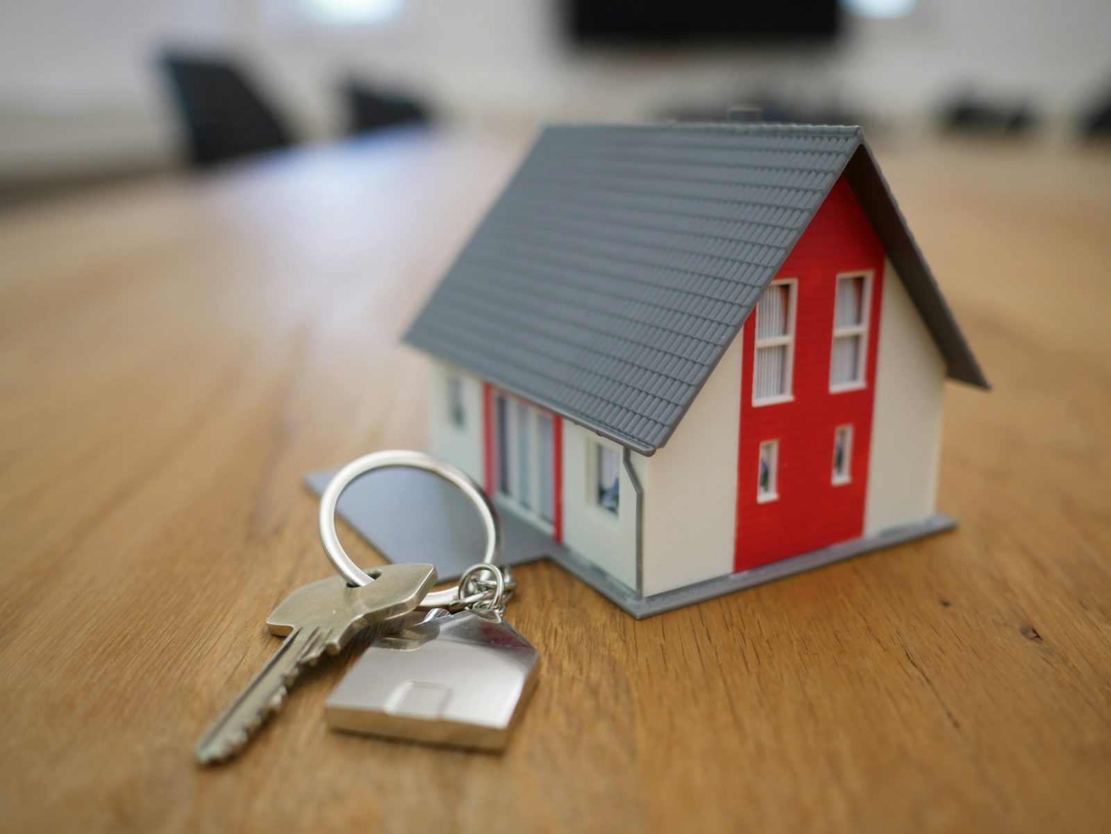 A model house beside a set of keys on a wooden table
