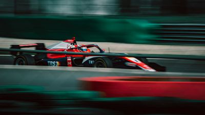 A Formula car at speed, panned